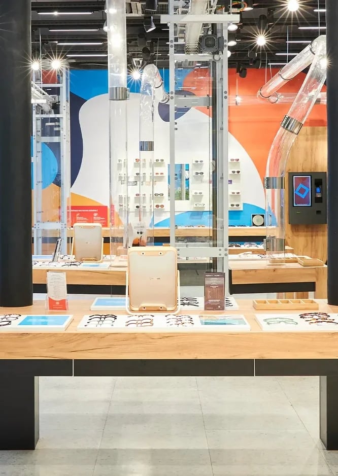 Inside the Lunettes Pour Tous flagship, with its frame tables and glass-walled workshop