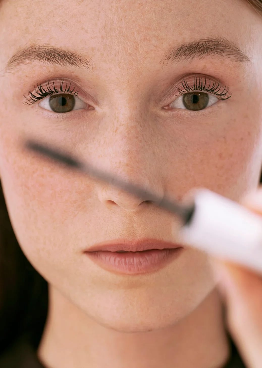 A woman applying Oh My Cream! mascara